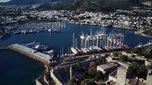 View from drone on full of yachts Bodrum harbour and ancient Kalesi castle in Mugla in Turkey