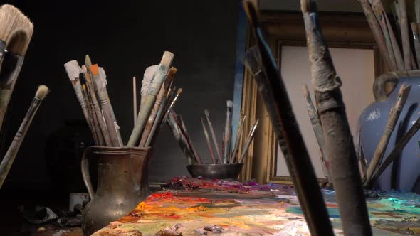 Art studio interior with tools for painting - Brushes, oil paints, palette, canvas, easel