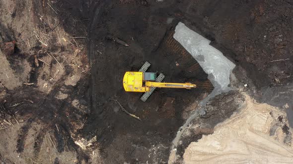 Excavator digs the ground at a construction site, Aerial view, Industrial style