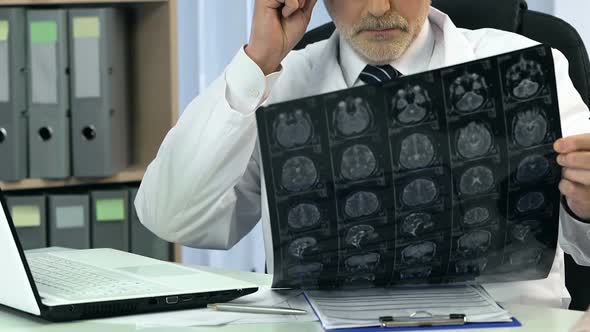 Neurosurgeon Analyzing Brain X-Ray and Talking With Female About Her Headache