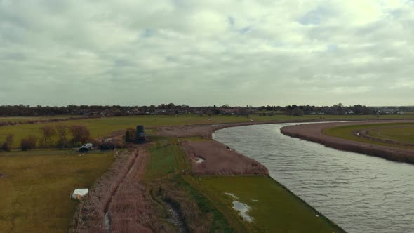 Aerial drone static shot of Norfolk Broads canal waterway on overcast cloudy day