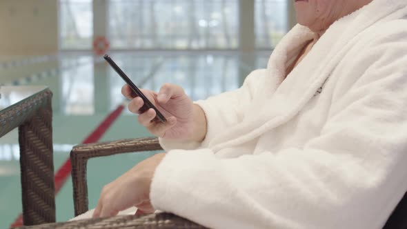 Old Man Using Telephone in Swimming Pool