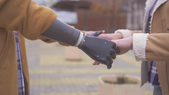 Close Up of Girl Holding Hands of Man with Cyber Prosthesis Hands