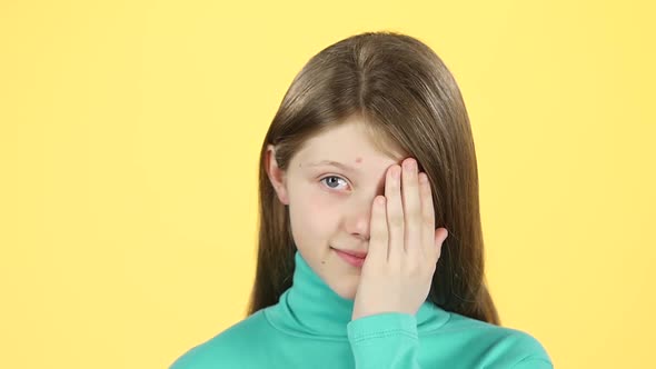 Close-up Little Female Covers Her Face with Hands Then Cute Smile. Slow Motion