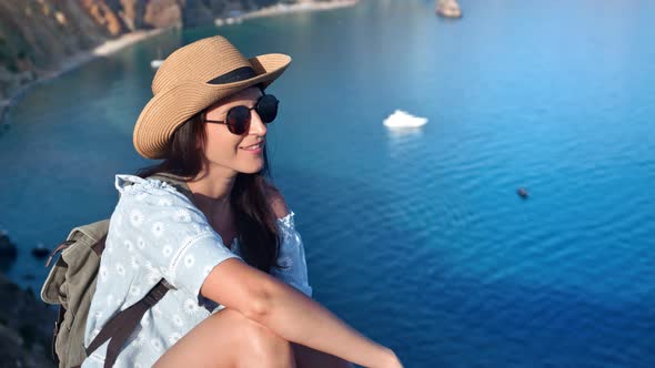 Smiling Travel Woman in Hat and Sunglasses Enjoying Sea Surrounded By Mountain View