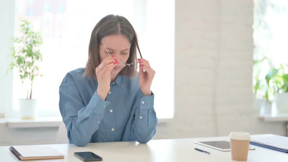 Young Woman having Headache in Modern Office