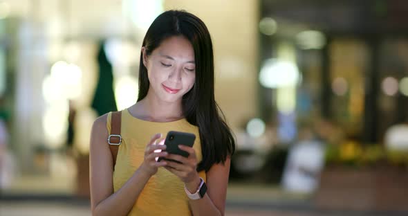 Woman working on cellphone at night