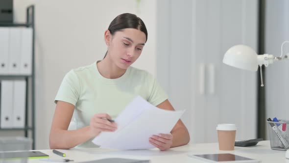 Excited Young Latin Woman Celebrating After Reading Documents