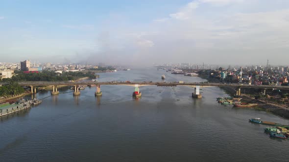 Aerial flight over traffic on four lane Postogola bridge over Buriganga river. Bangladesh
