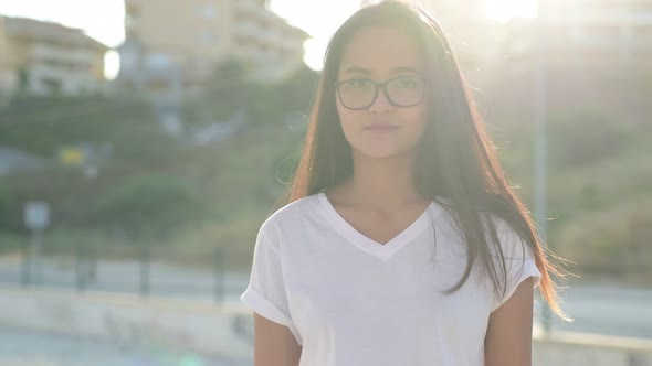 Young Beautiful Asian Tourist Woman Smiling Against Sunlight At The Train Station