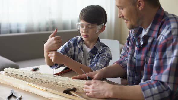 Father Teaching His Smiling Son Carpentry, Little Boy Using Screwer at Workshop