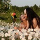 Slow Motion of Young Attractive Mother with Son Playing Windmill Sitting in Flower Field at Sunset. - VideoHive Item for Sale