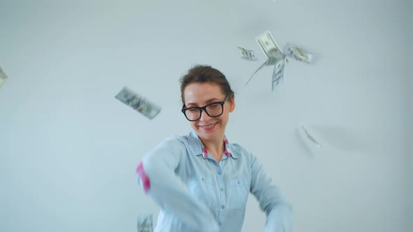 Happy Woman with Glasses Making Money Rain From Dollar Bills