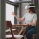 Young woman sitting on the balcony experiencing virtual reality in the metaverse - VideoHive Item for Sale