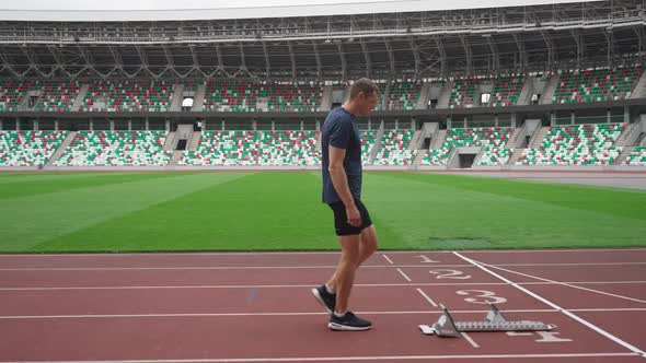 Stadium Man Sprinter is Preparing for the Start of a Training Run in Shortdistance  Slow Motion