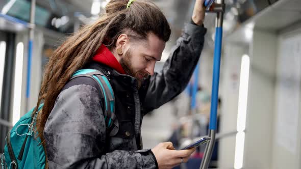 Young Man in Metro Train Hipster is Using Underground for Transporting in City Public Transport