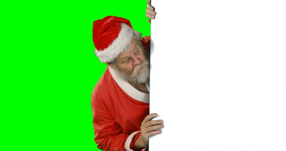 Surprised santa claus hiding behind green screen