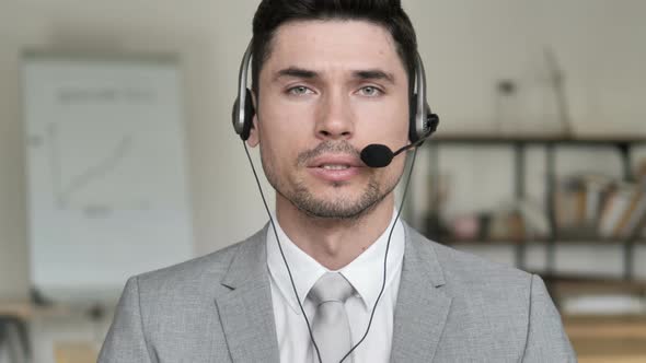 Call Center Man Talking via Headphones