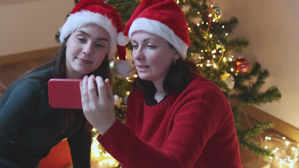 Two Female Red Santa Hats Talking Video Call Using Smartphone Christmas New Year