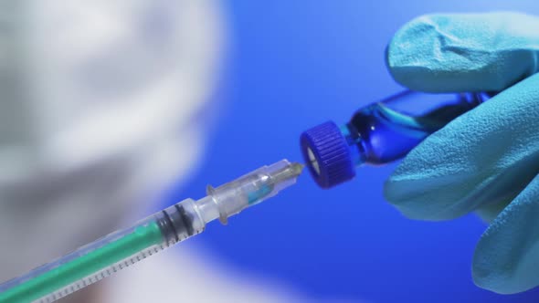 Doctor Draws a Blue Drug Into a Syringe