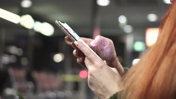 Close-up of Female Hands Using Smartphone in Night City