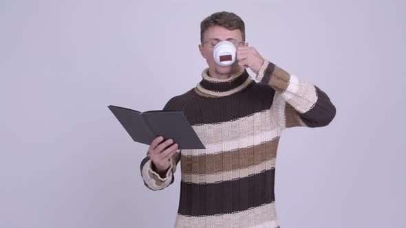 Handsome Bearded Man Reading Book While Drinking Coffee