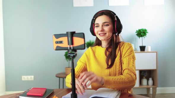 Happy Young Teacher in Headphones Communicates By Video Call Using Mobile Phone