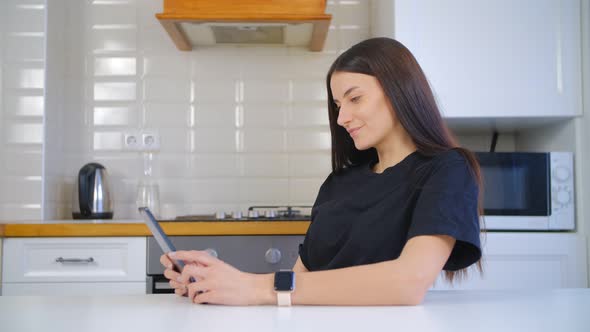 Young white woman browsing internet on modern tablet pc device at home in 4k footage
