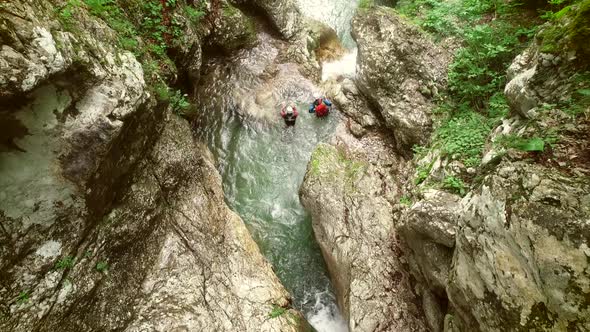 Aerial view of couple jumping in sliding rock at Soca river, Slovenia.