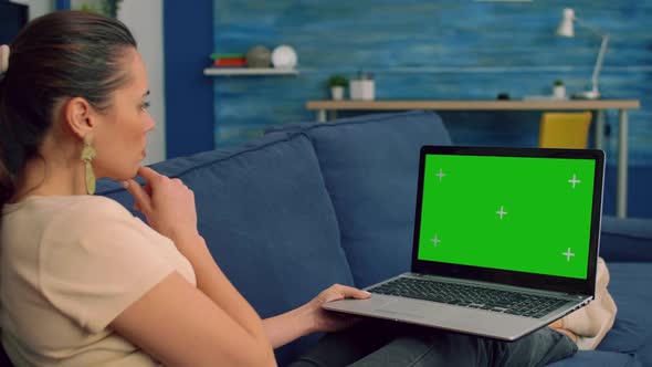 Tracking Shot of Freelencer Woman Typing on Mock Up Green Screen Chroma Key Laptop Computer