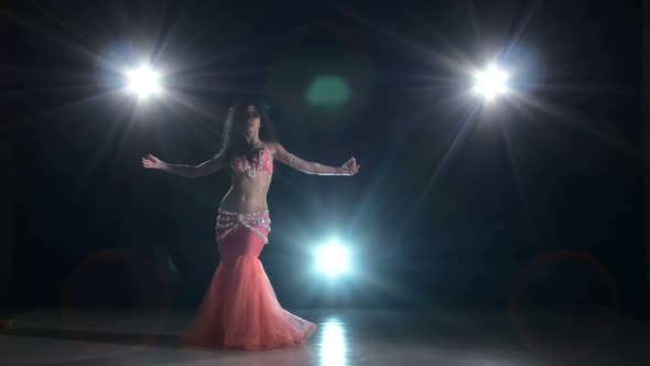 Beautiful Belly Dancer Girl Continue Dancing Exotic Dance on Black, Back Light