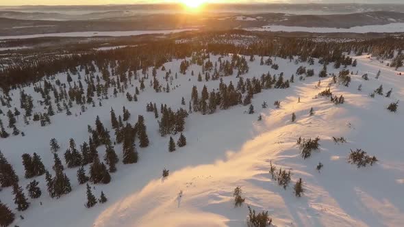 Aerial view of winter landscape sunset or sunrise with yellow sunburst, stunning fairy-tale christma