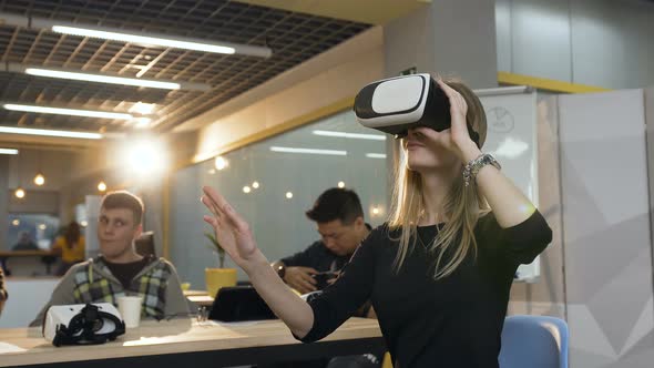 Young Caucasian Business Woman Wearing Virtual Reality Glasses Working in the Office