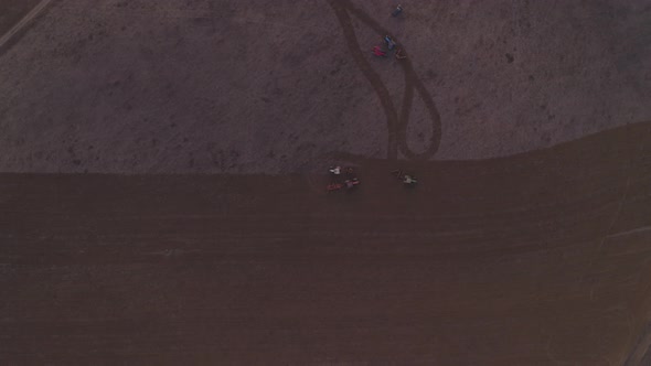 Tractors on a rural field drone aerial top view at sunset in Alentejo, Portugal