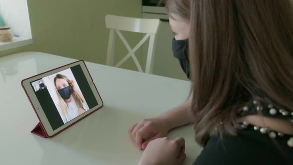 Two Young Women Are Talking Via Video Link in Medical Masks