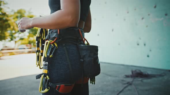 Professional Climber Preparing Carbines Before Practice at Outdoor Artificial Rock Close Up