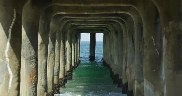 Waves splash and crash under pier