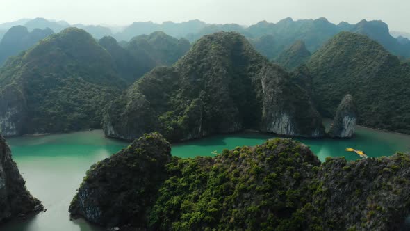 Aerial: flying over Ha Long Bay rock pinnacles, famous tourism destination in Vietnam