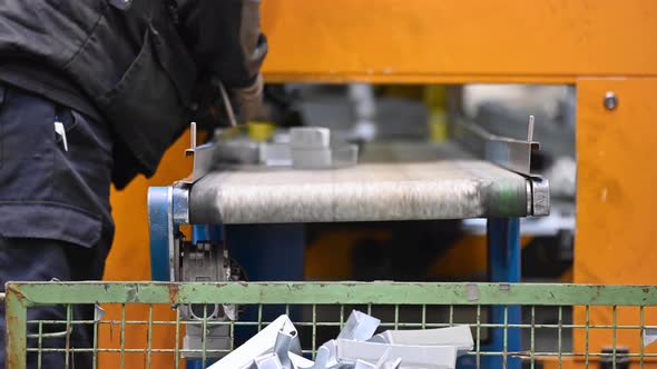 Operator Working at Factory Conveyor Belt. Industrial Manufacturing Process. Metal Stamped Pieces