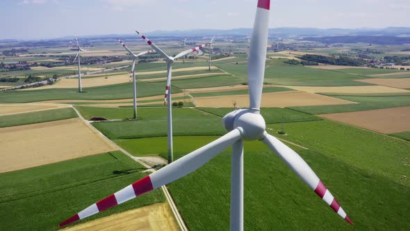 Aerial flight near wind turbines. Clear renewable energy production. Farm landscape.
