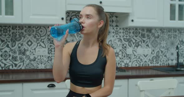 Beautiful Woman Drinking Water and Resting After Training at Home. Healthy Lifestyle New Normal