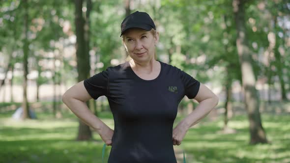 Portrait of Confident Mid-adult Woman Measuring Waist Outdoors. Slim Beautiful Caucasian Sportswoman