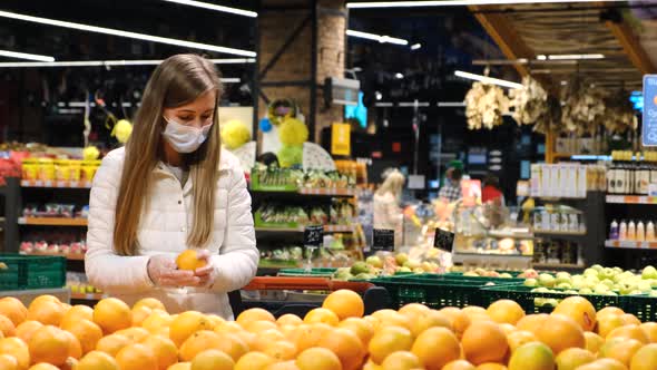 A European Woman Buys Citrus Fruits at the Fruit Market