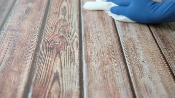 Man Hand in Blue Gloves Cleaning Wooden Surface 