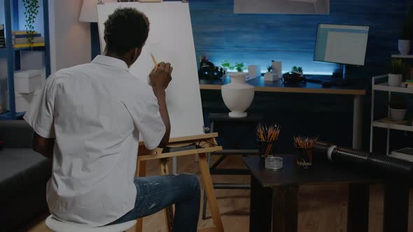 African American Artist Working on White Canvas with Drawing