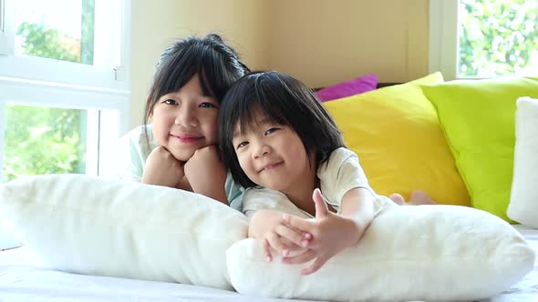 Cute Asian Children Playing On A Bed