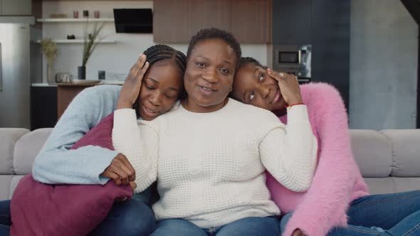 Caring Mom and Adolescent Daughters Bonding on Couch