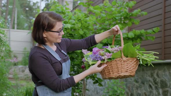 Woman Gardener Florist in Garden with Basket of Fresh Plucked Garden Spring Flowers