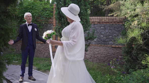 Cheerful Laughing Senior Bride Looking Back at Happy Groom Turning Looking at Camera Smiling