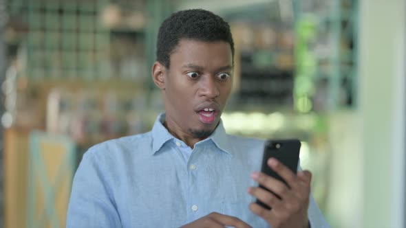 Portrait of Upset Young African Man Having Loss on Smartphone